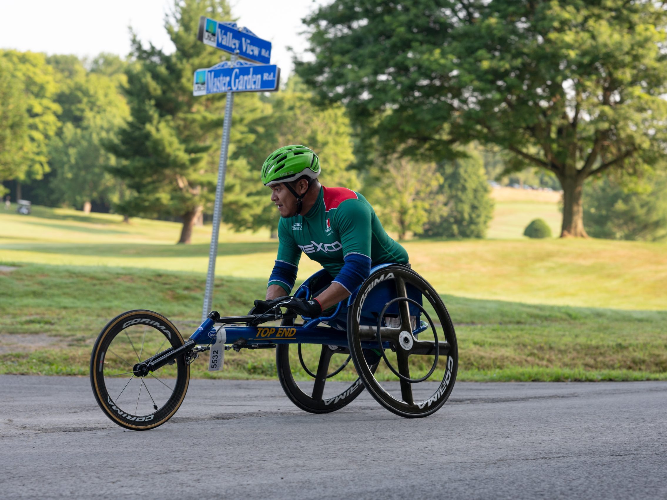 A wheelchair competitor races uphill along the Valley View golf course