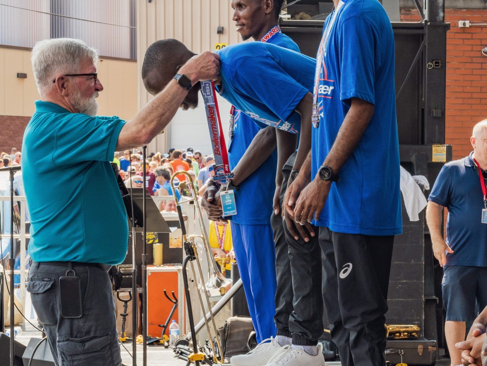 Boilermaker Race Director, Jim Stasaitis, presents the winner of the 2024 Boilermaker, John Korir, with his medal.