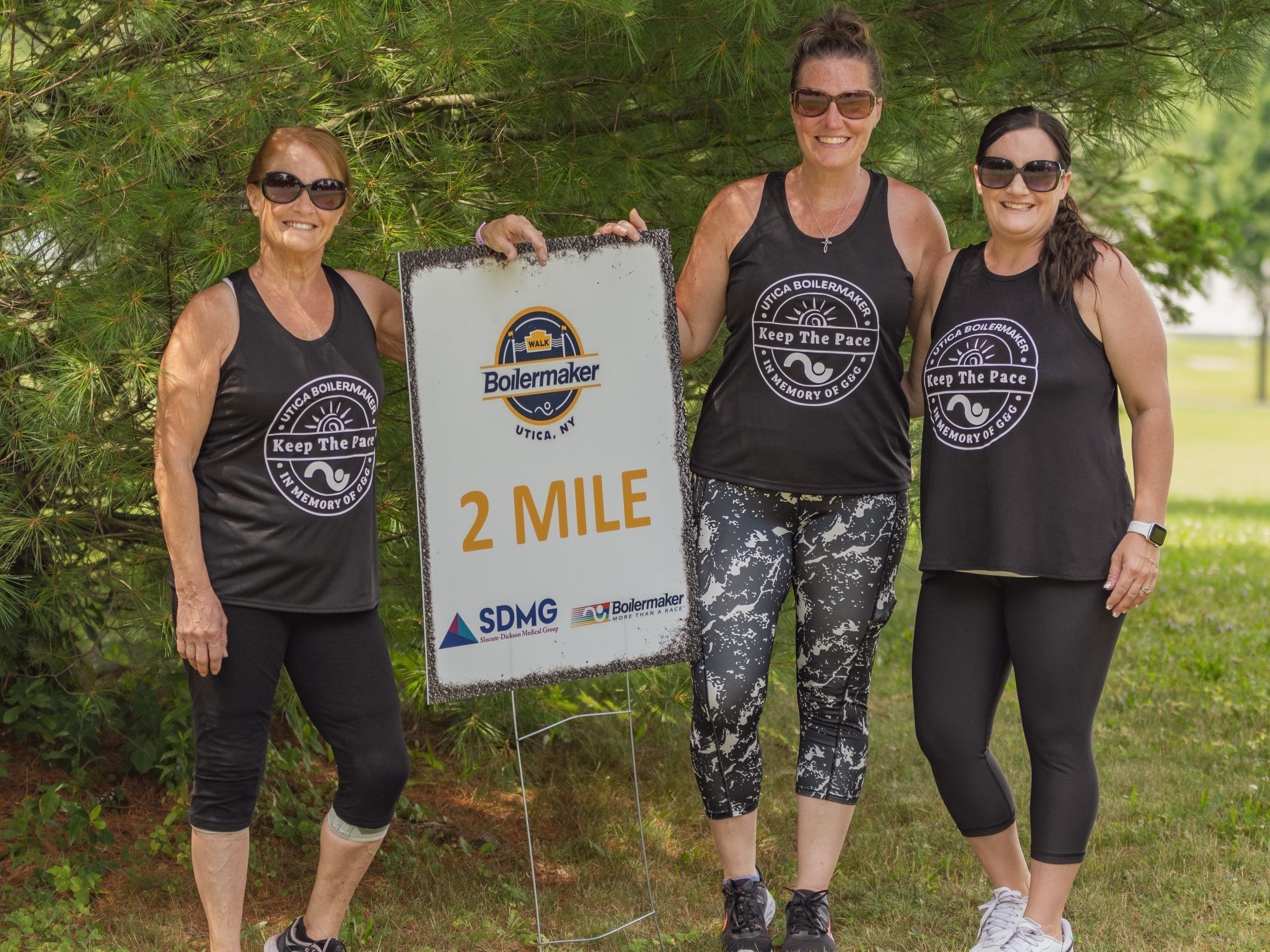 A group of walkers in matching Boilermaker shirts pose with the 2 mile marker