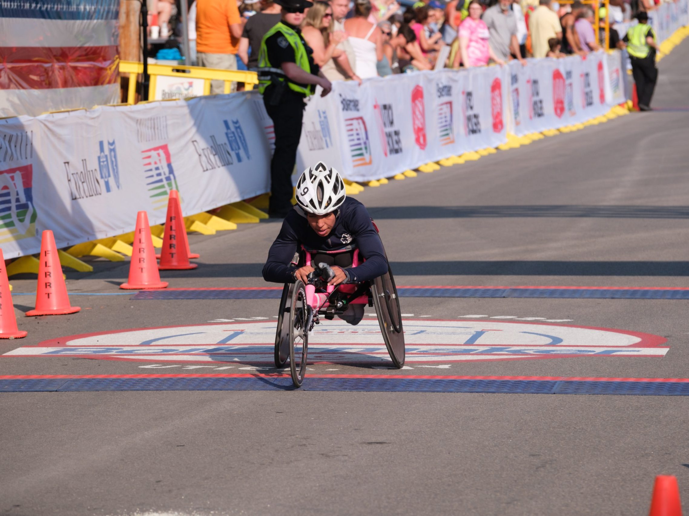 Wheelchair racer crosses the finish line of the 2024 Boilermaker 15K