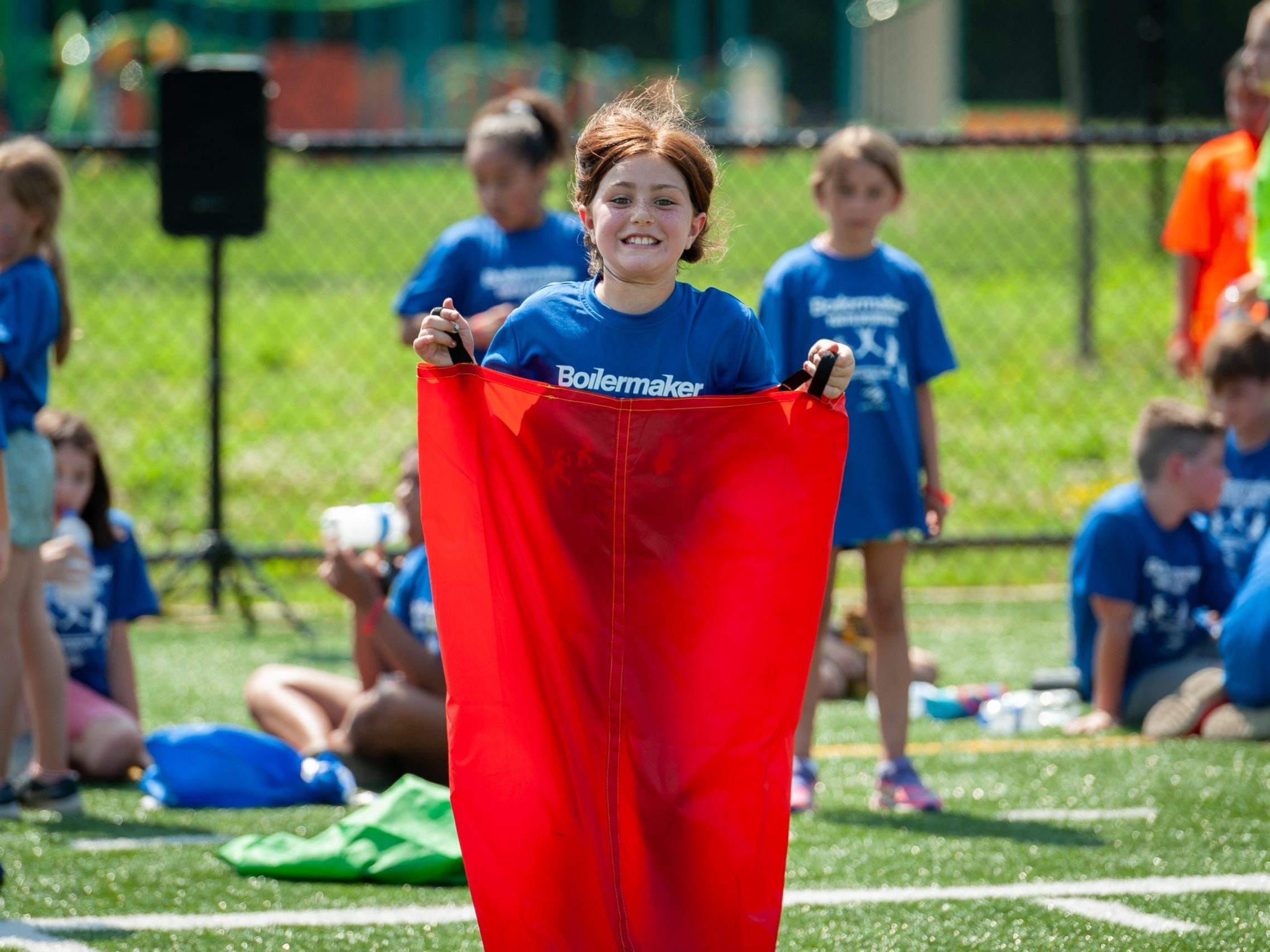 A child is all smiles during a sack race in the 2023 Boilermaker Youth Olympics