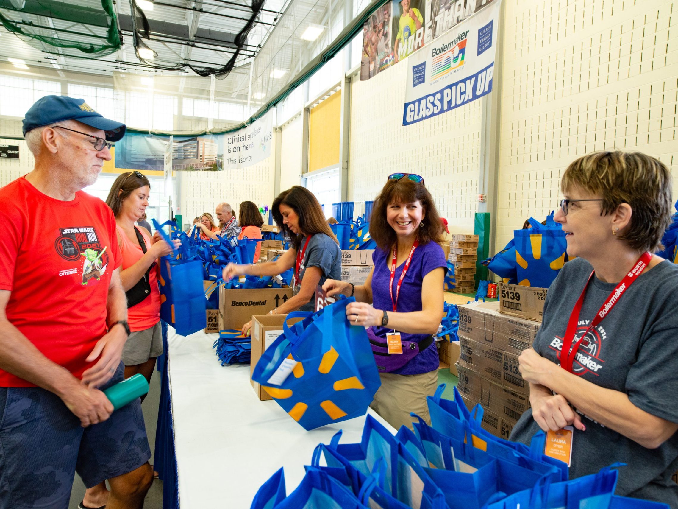 A participant picks up a Walmart bag with their race incentives at the Health & Wellness expo