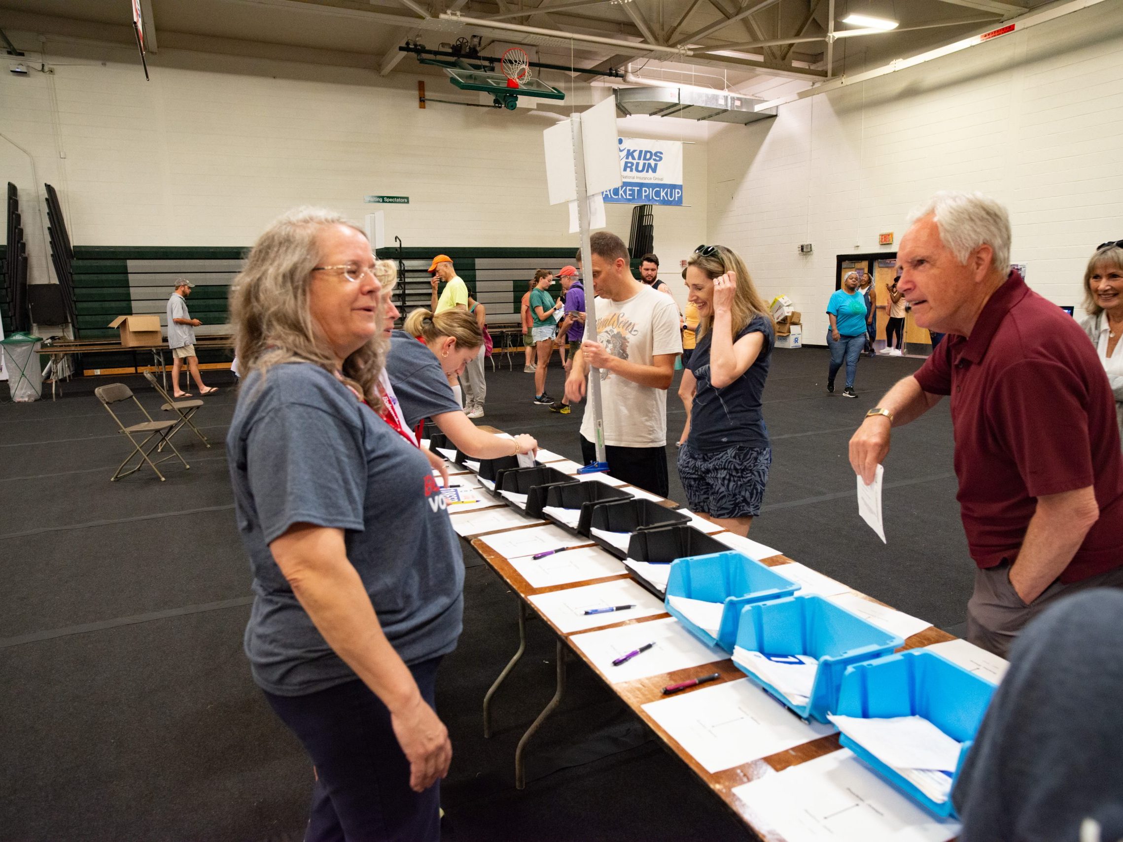 A volunteer speaks to a participant picking up their bib at the Health & Wellness expo.