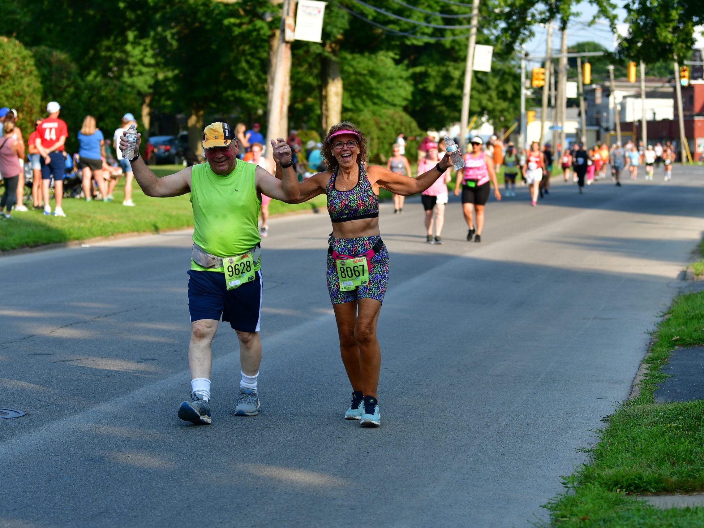 Two participants of the Boilermaker 5K smile and hold hands as they look to the camera