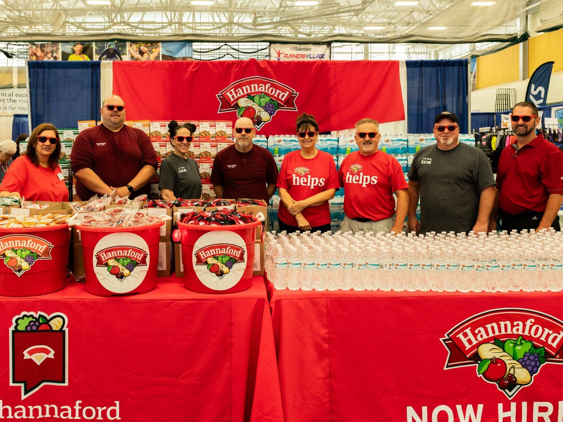 Hannaford team poses with their freebies and tables at the Boilermaker Health & Wellness Expo