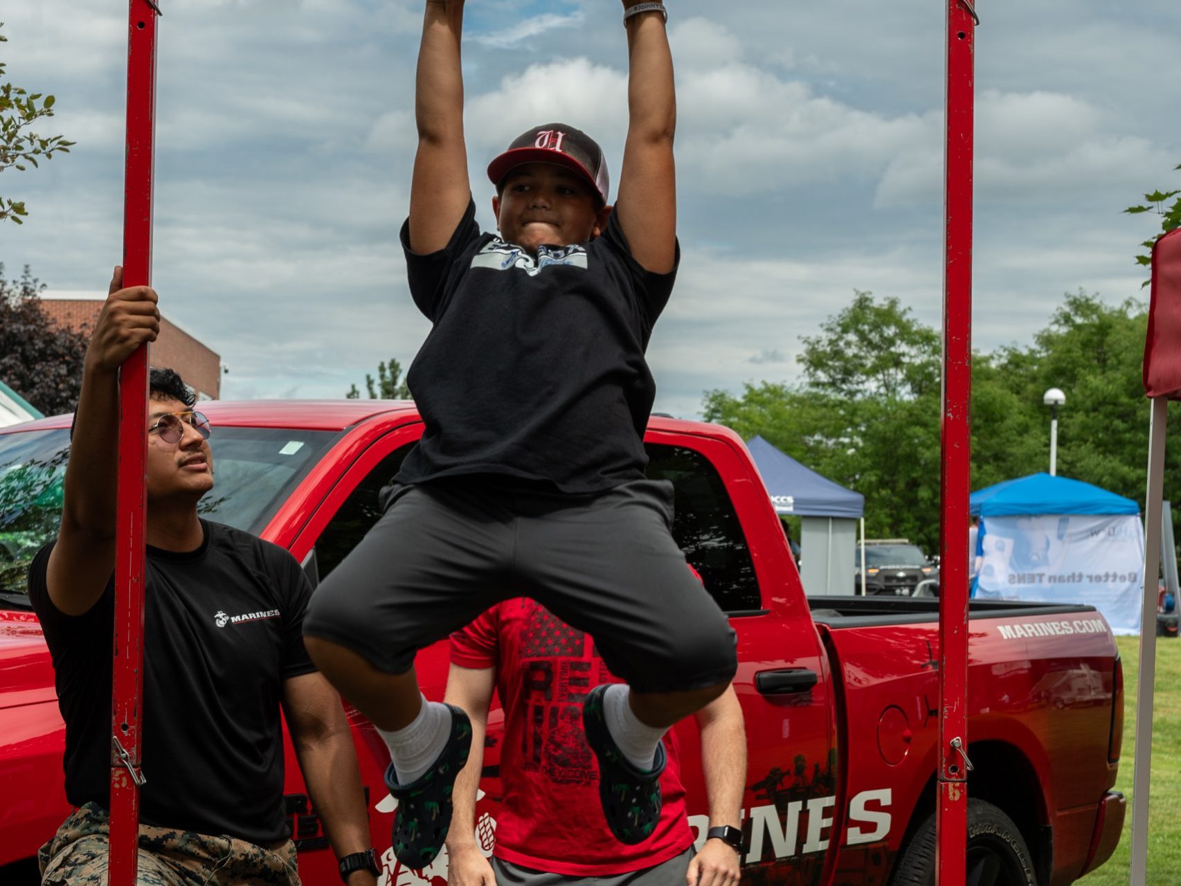 A child does a pull up with the Marines outside the Boilermaker Health and Wellness Expo