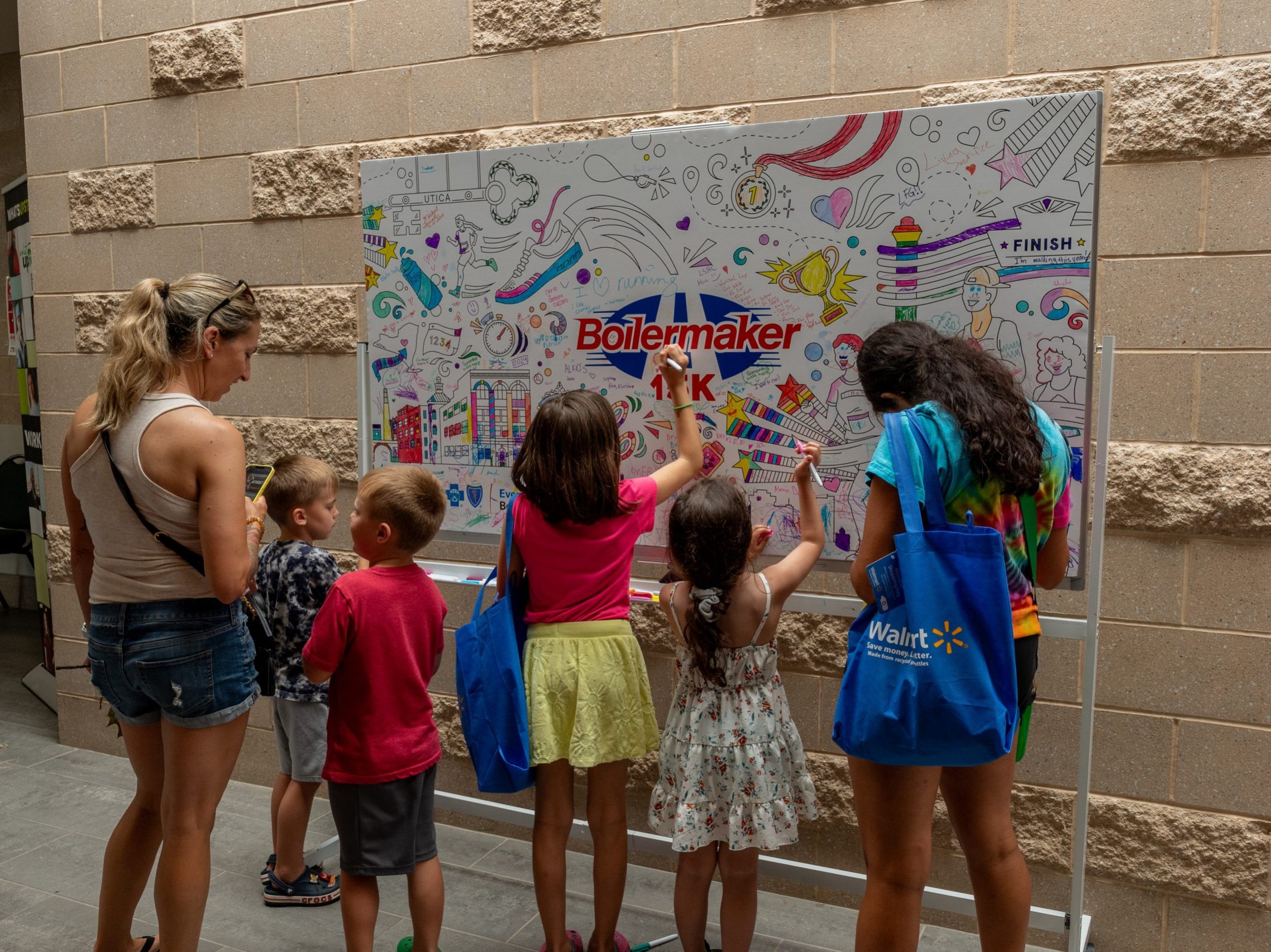 Children color on a banner at the Health and Wellness expo