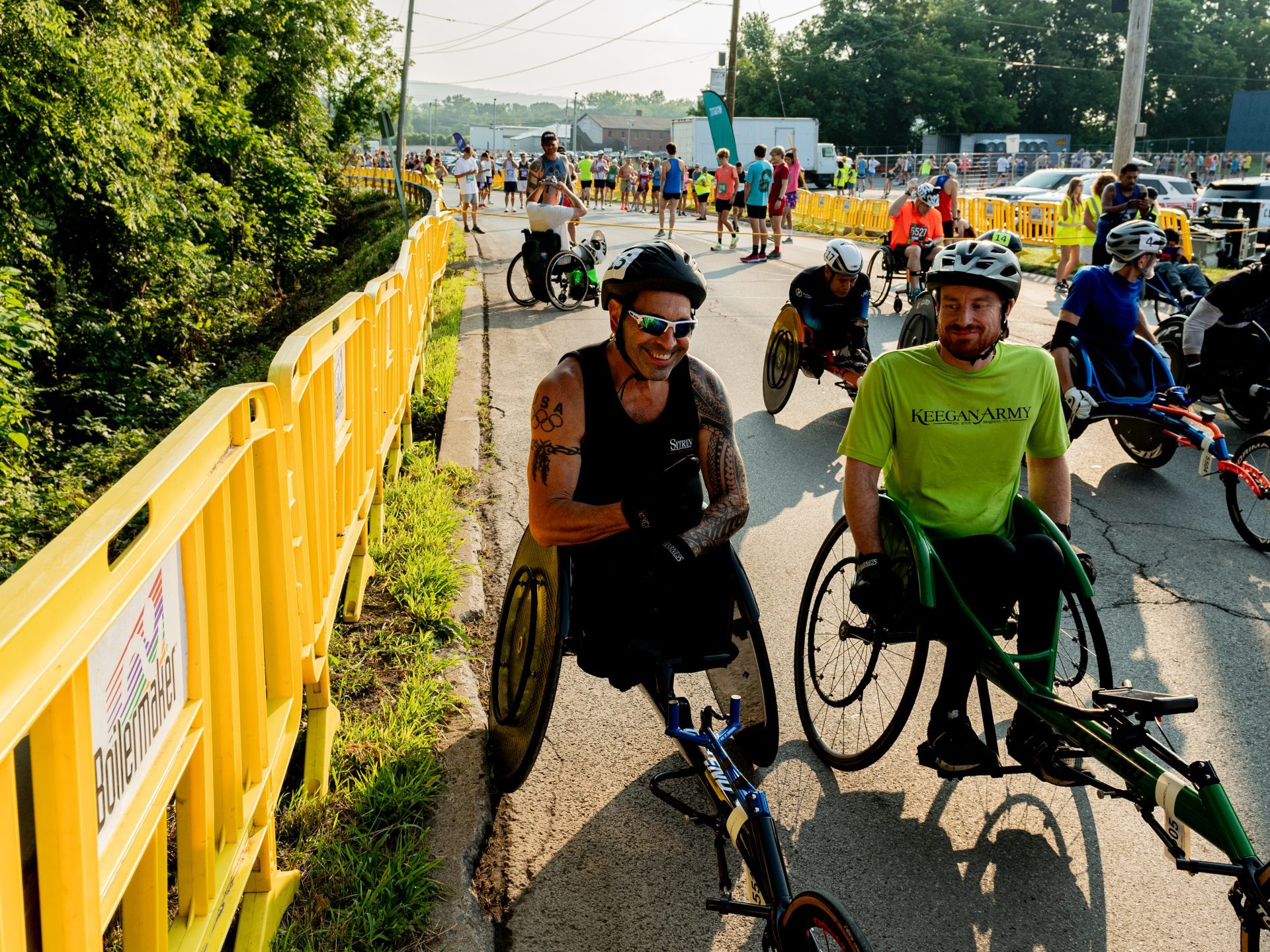 Two wheelchair racers chat and smile before the start