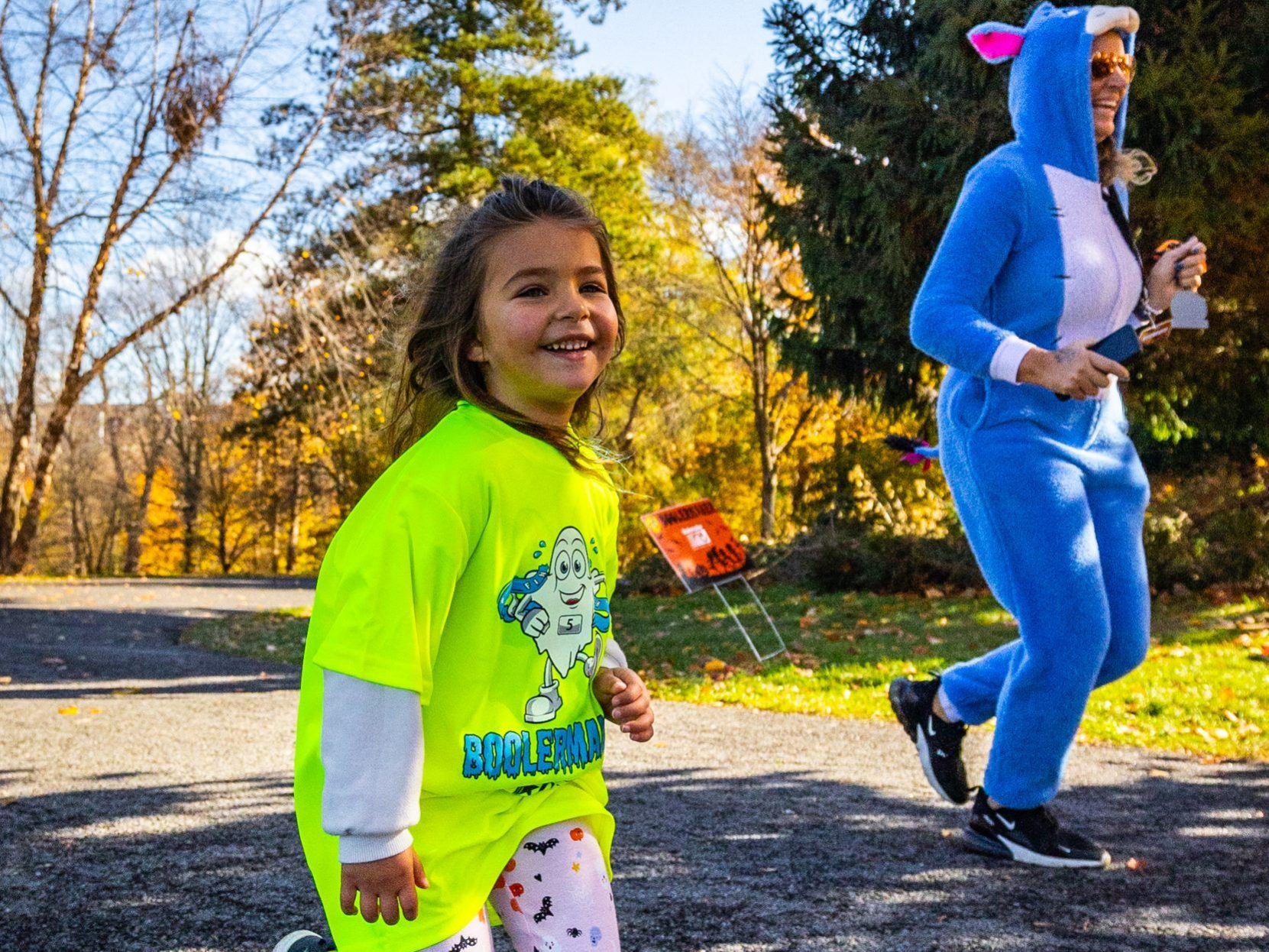 A girl in a Boolermaker T-Shirt smiles as she runs