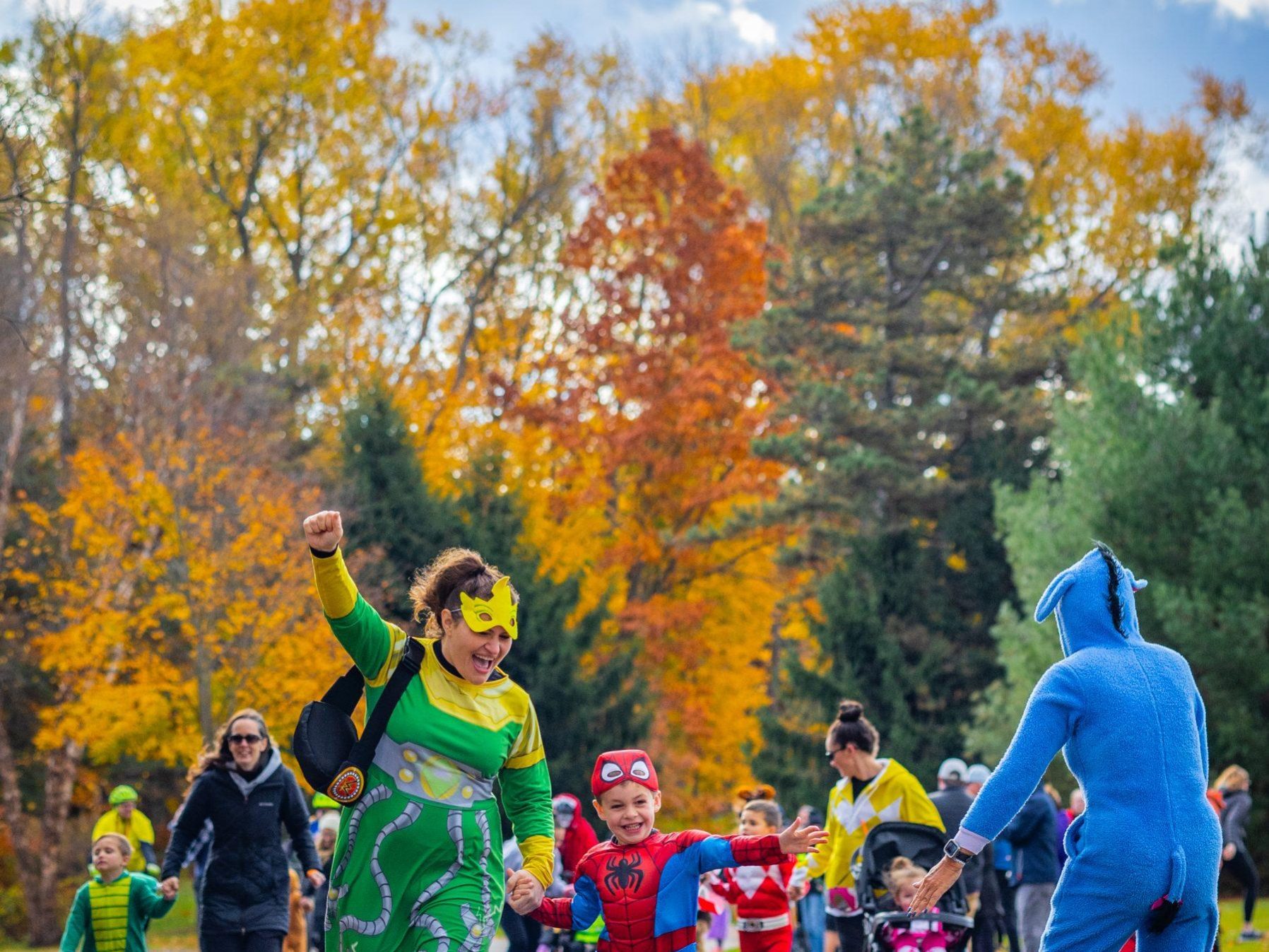 A boy and his mother smile while running hand in hand