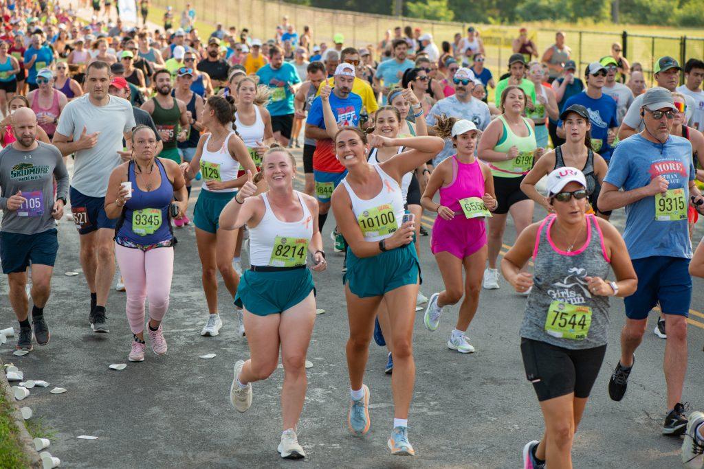 Runners participating in the 2025 Boilermaker Road Race 15K smile mid-race.