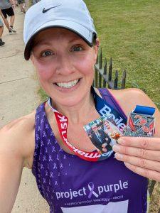 A runner for Project Purple showcases her 2025 Boilermaker medal and a photo.